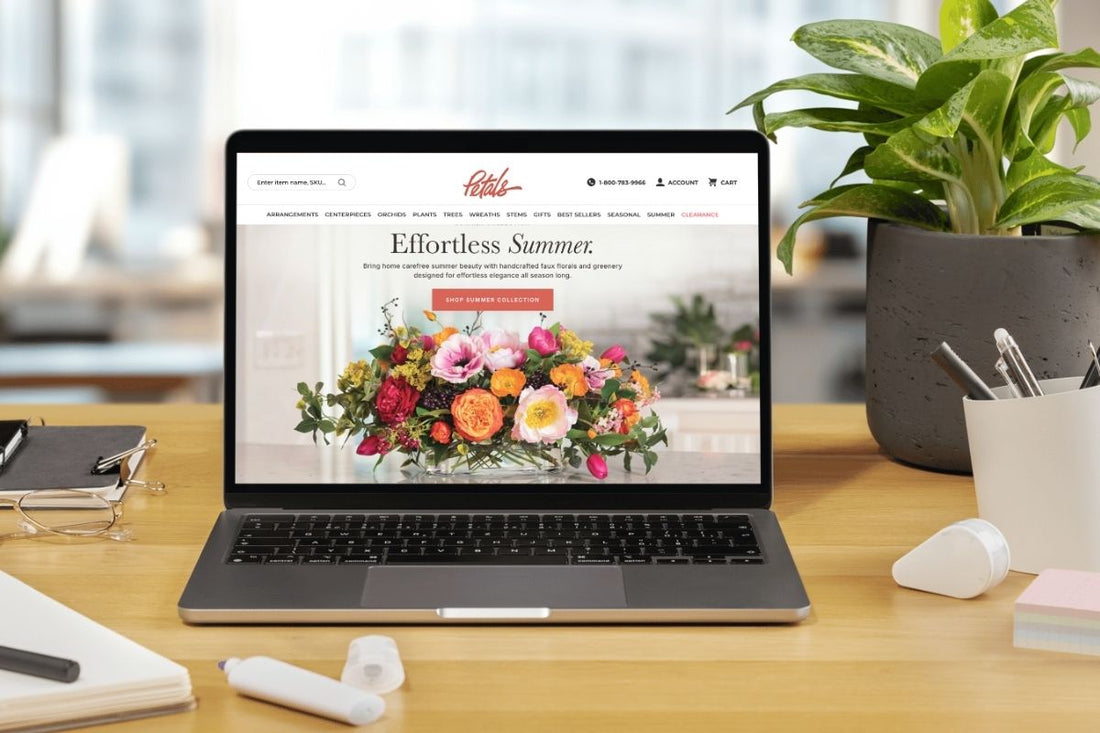 An ecommerce migration concept graphic featuring a laptop on a table with a flower retailer website. 